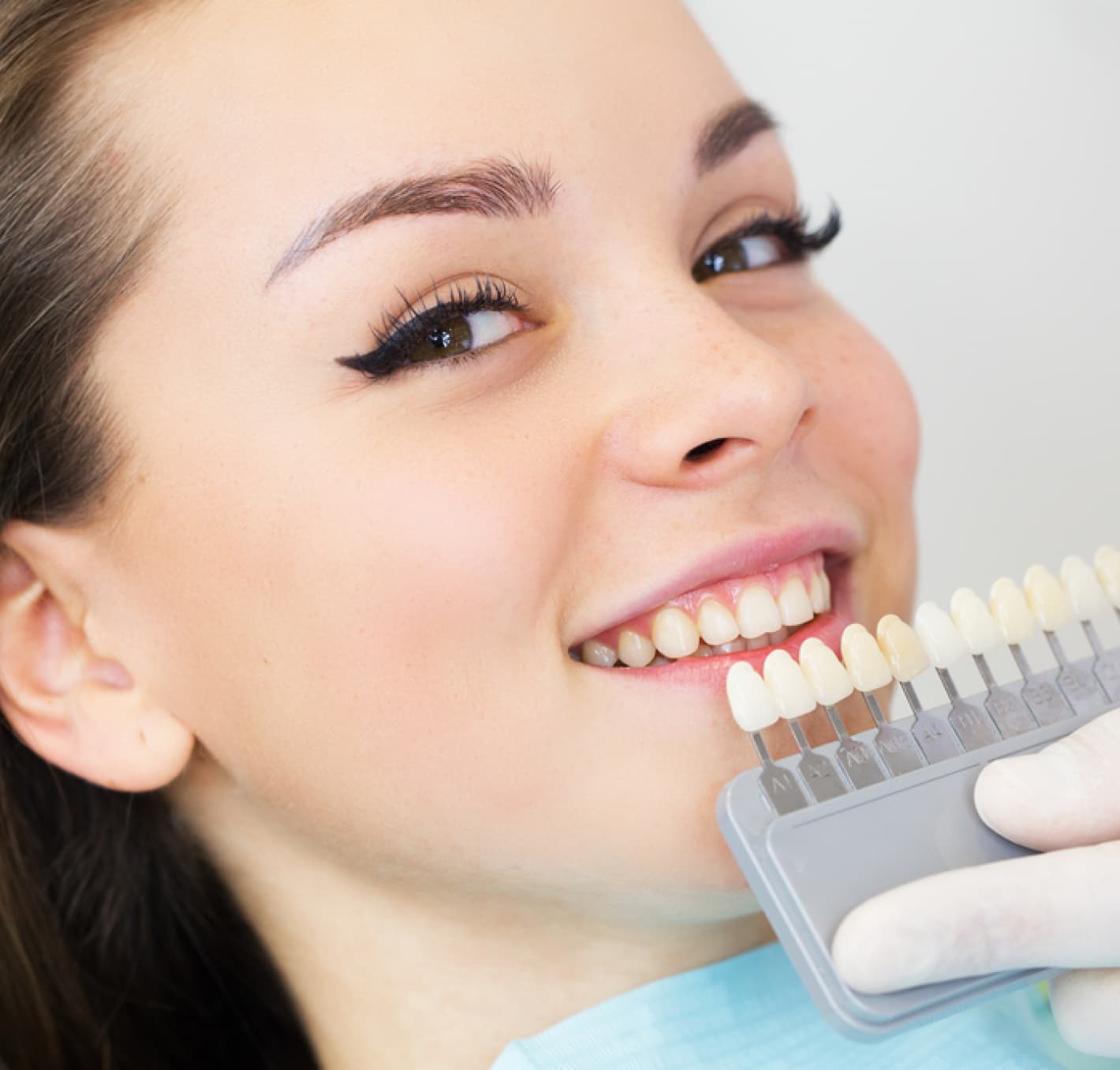 A patient choosing a tooth shade with her dentist
